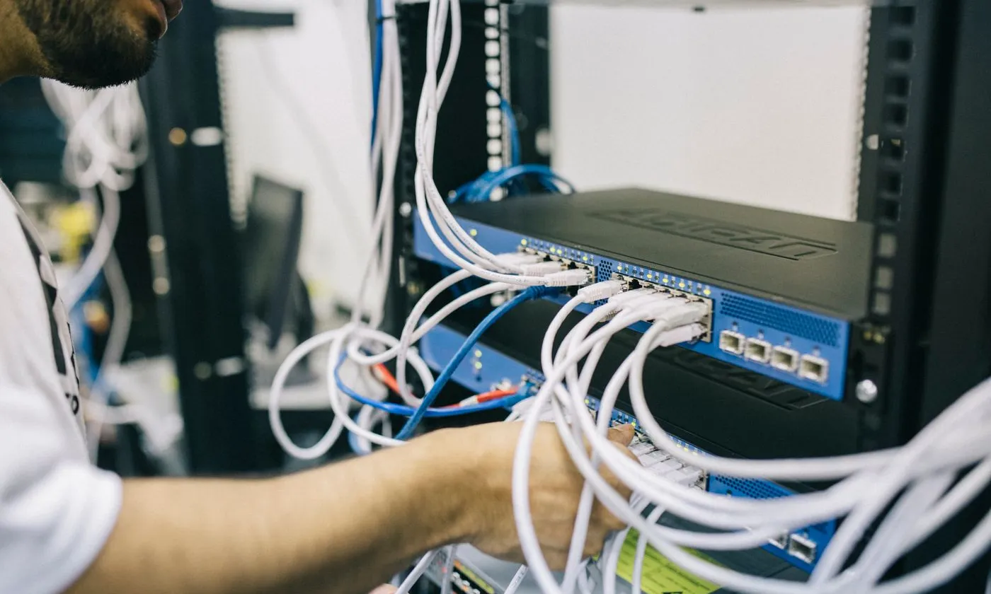 Technician working on connections inside a network cabinet